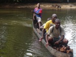 Children in Crisis FAWE teacher trainer crossing river in canoe