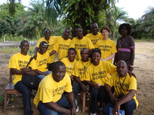 The artist/FAWE team heads to the field for a pilot project. Pictured are (left to right): Back row: George Njanjaine (FAWE Community Mobiliser), Adolphus Seekie, Cephas B Williams, Moses J Tarpeh, Alison Lloyd Williams, Satta Gbelee (FAWE Trainer – Community Mobilisation) Middle row: James Harris, David Chea, Comfort Ward, Edward Slewion, Christiana Weah, Christian Plakar (FAWE Trainer – Literacy) Front: Karwah Kopah (FAWE Community Mobiliser) (Photograph taken by: Juliet Matthews, Children in Crisis/FAWE Literacy Specialist) 